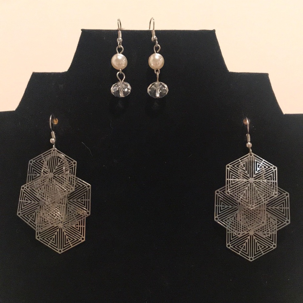 2 pairs of silver colored dangle earrings.